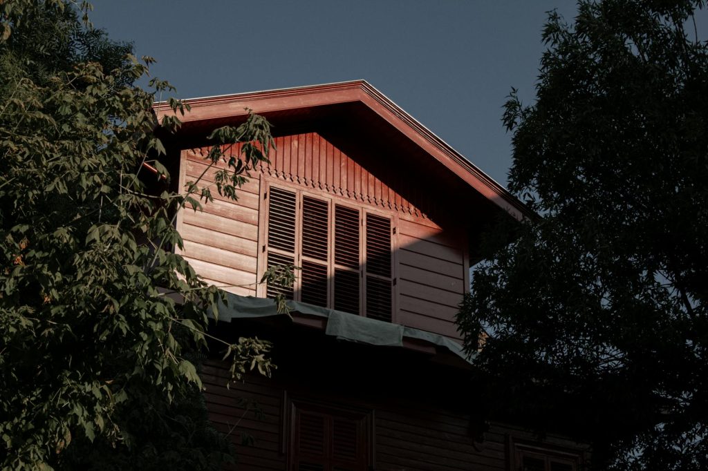 A serene view of an Ottoman-style wooden house surrounded by lush trees in Heybeliada, Turkey.