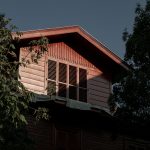 A serene view of an Ottoman-style wooden house surrounded by lush trees in Heybeliada, Turkey.