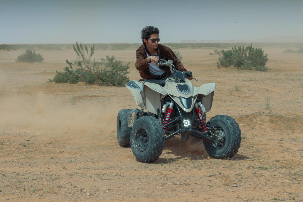 Dynamic shot of a person enjoying quad biking in Riyadh's desert landscape.