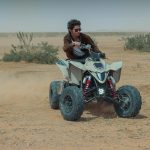 Dynamic shot of a person enjoying quad biking in Riyadh's desert landscape.