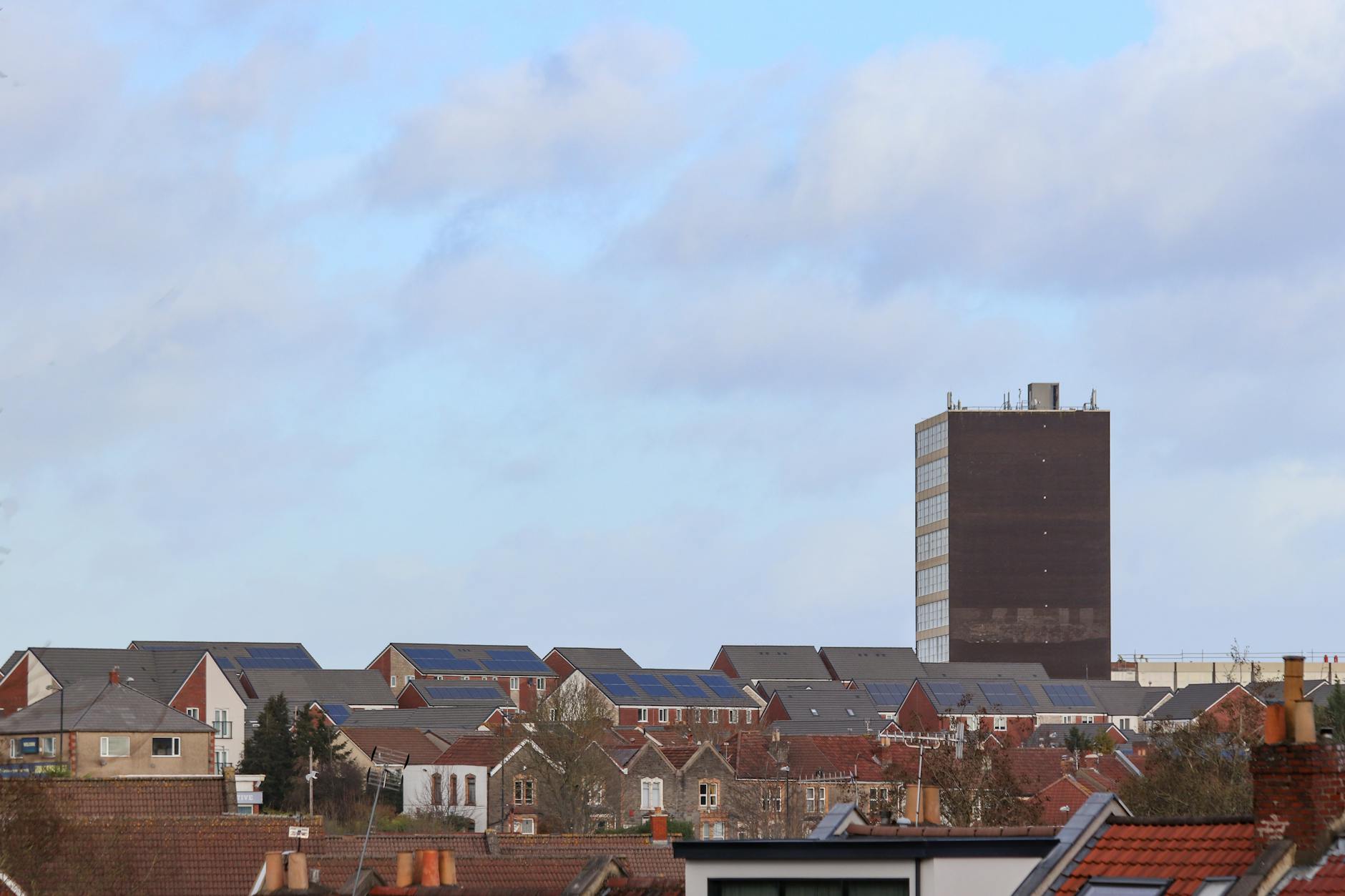 Scenic view of Bristol's urban rooftops featuring solar panels and a tall building.