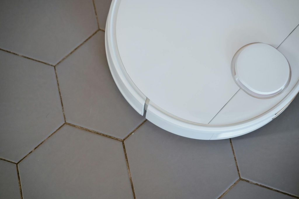 Close-up of a robotic vacuum cleaner on hexagonal tiles for efficient cleaning.