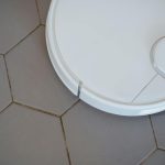 Close-up of a robotic vacuum cleaner on hexagonal tiles for efficient cleaning.