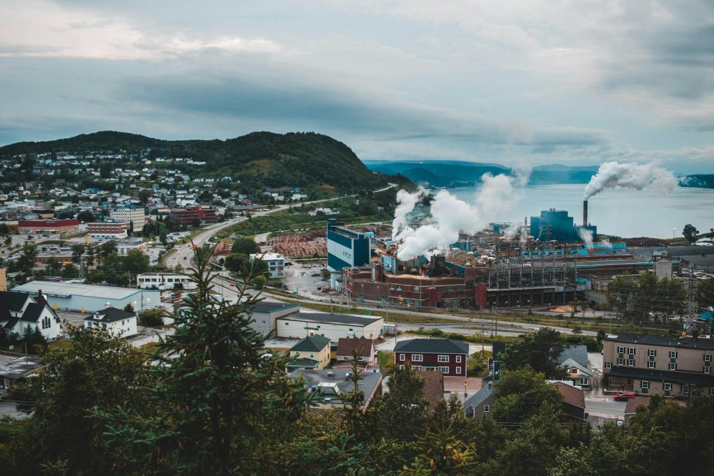 Aerial view of a city with factories emitting smoke, showing urban industry.