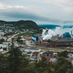 Aerial view of a city with factories emitting smoke, showing urban industry.