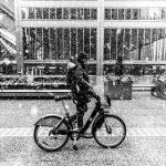 A man rides a bike in a snow-covered downtown Toronto during winter.