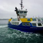 The Christopher Stannix ferry navigating the waters at Halifax harbor on a cloudy day.