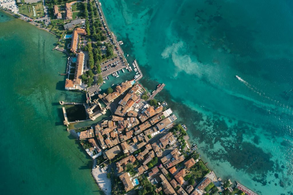 Aerial shot of a coastal town with clear turquoise waters and residential buildings.