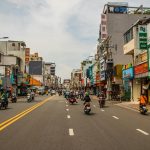 Vibrant street view of motorbikes and shops in Ho Chi Minh City, showcasing urban life.