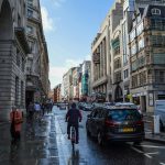 Crowded street with old shabby buildings and transport under clear bright blue sky