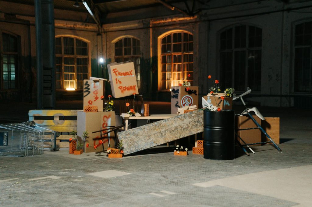 Creative protest arrangement with placards and flowers in an industrial space.