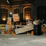 Creative protest arrangement with placards and flowers in an industrial space.