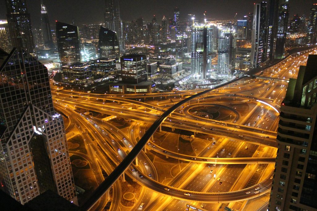 Stunning aerial view of Dubai's illuminated highways and skyscrapers at night.