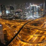 Stunning aerial view of Dubai's illuminated highways and skyscrapers at night.