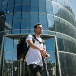 Young courier in urban setting delivering packages on an electric scooter.