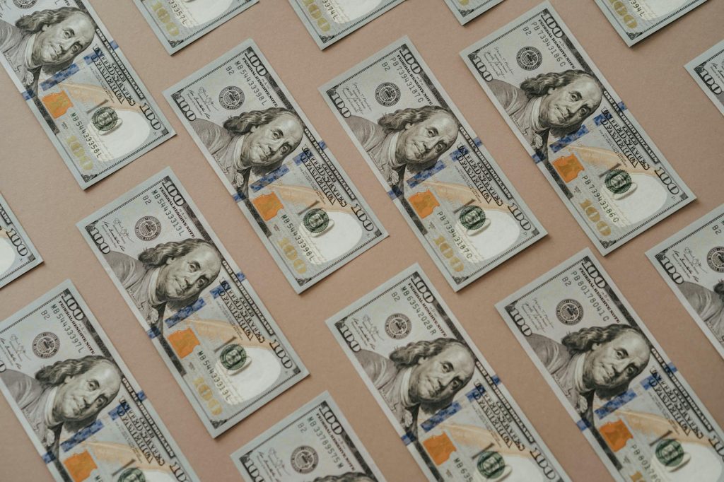 Close-up of multiple US dollar bills arranged in a grid pattern.