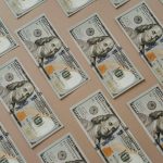 Close-up of multiple US dollar bills arranged in a grid pattern.