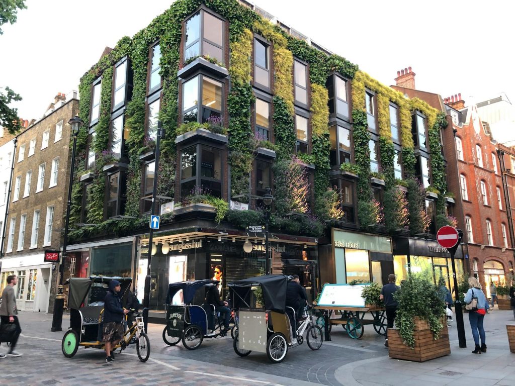 Victorian building with vertical garden facade in busy London street.