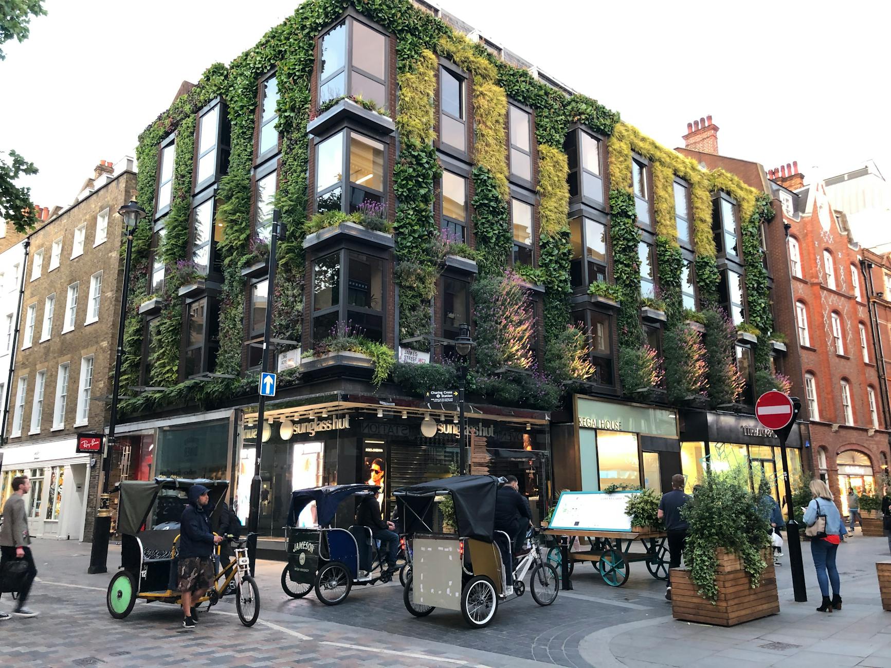 Victorian building with vertical garden facade in busy London street.